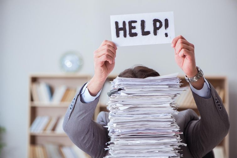 Frustrated homeowner holding "Help!" sign over stack of rebate applications