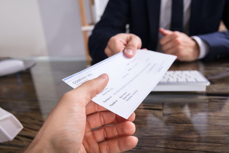 Tax expert handing cheque for GST/HST credit to client